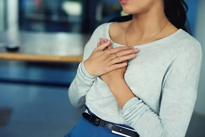 jeune femme qui pose ses deux mains sur le coeur